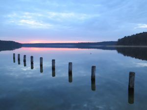 Sonnenuntergang und Pfähle im See