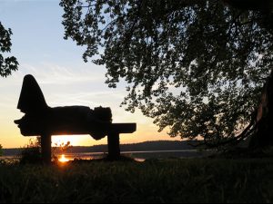 Sonnenuntergang am Stechlinsee - eine Frau liegt auf einer Bank