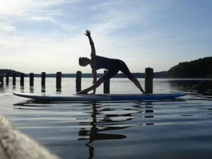 Angela praktiziert Yoga auf dem SUP im Stechlinsee